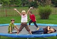 famille sur un trampoline de jardin